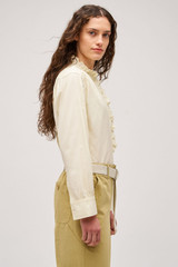 Profile view of model wearing the  Hazel Ruffle Blouse in Vanilla Crème and Made from 100% poplin cotton  for Men