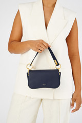 Profile view of model wearing the Oroton Liv Small Day Bag in Fisherman Blue and Pebble leather for Women