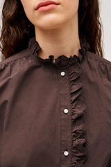 Profile view of model wearing the  Hazel Ruffle Blouse in Chocolate and Made from 100% poplin cotton  for Men
