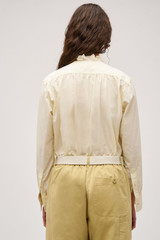 Profile view of model wearing the  Hazel Ruffle Blouse in Vanilla Crème and Made from 100% poplin cotton  for Men