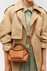 Profile view of model wearing the Oroton Mica Mini Bowler in Brandy and Pebble leather for Women