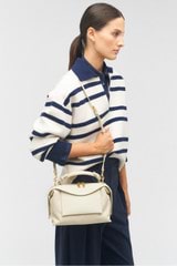 Profile view of model wearing the Oroton Mica Small Bowler in Cashew and Embossed leather with smooth leather trims for Women