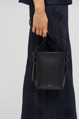 Profile view of model wearing the Oroton Ellis Crossbody in Black and Smooth leather for Women