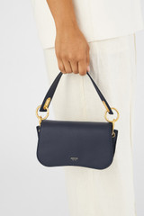 Profile view of model wearing the Oroton Liv Small Day Bag in Fisherman Blue and Pebble leather for Women
