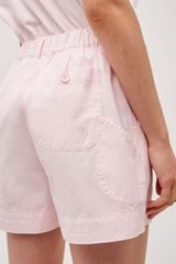 Profile view of model wearing the  Alfie Carpenter Short in Palest Pink and Crafted from cotton twill  for Men