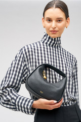 Profile view of model wearing the Oroton Clara Mini Bag in Black and Pebble leather for Women