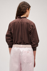 Profile view of model wearing the  Hazel Ruffle Blouse in Chocolate and Made from 100% poplin cotton  for Men