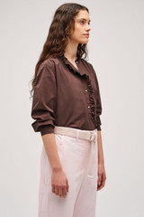 Profile view of model wearing the  Hazel Ruffle Blouse in Chocolate and Made from 100% poplin cotton  for Men