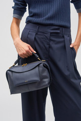 Profile view of model wearing the Oroton Mica Small Bowler in North Sea and Pebble leather for Women