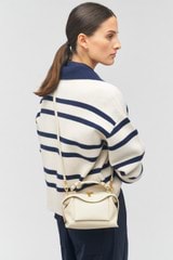 Profile view of model wearing the Oroton Mica Mini Bowler in Cashew and Pebble leather for Women