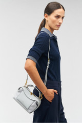 Profile view of model wearing the Oroton Mica Mini Bowler in Mist and Pebble leather for Women